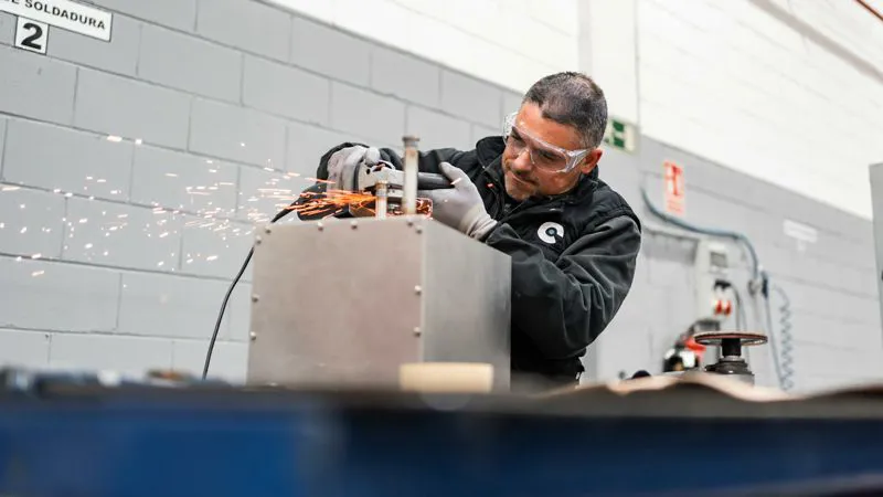 Operaio con dispositivi di protezione individuale durante una lavorazione con scintille