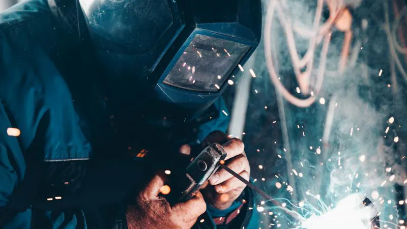 Saldatore al lavoro: abbigliamento ignifugo e multiprotezione per lavorazioni a caldo